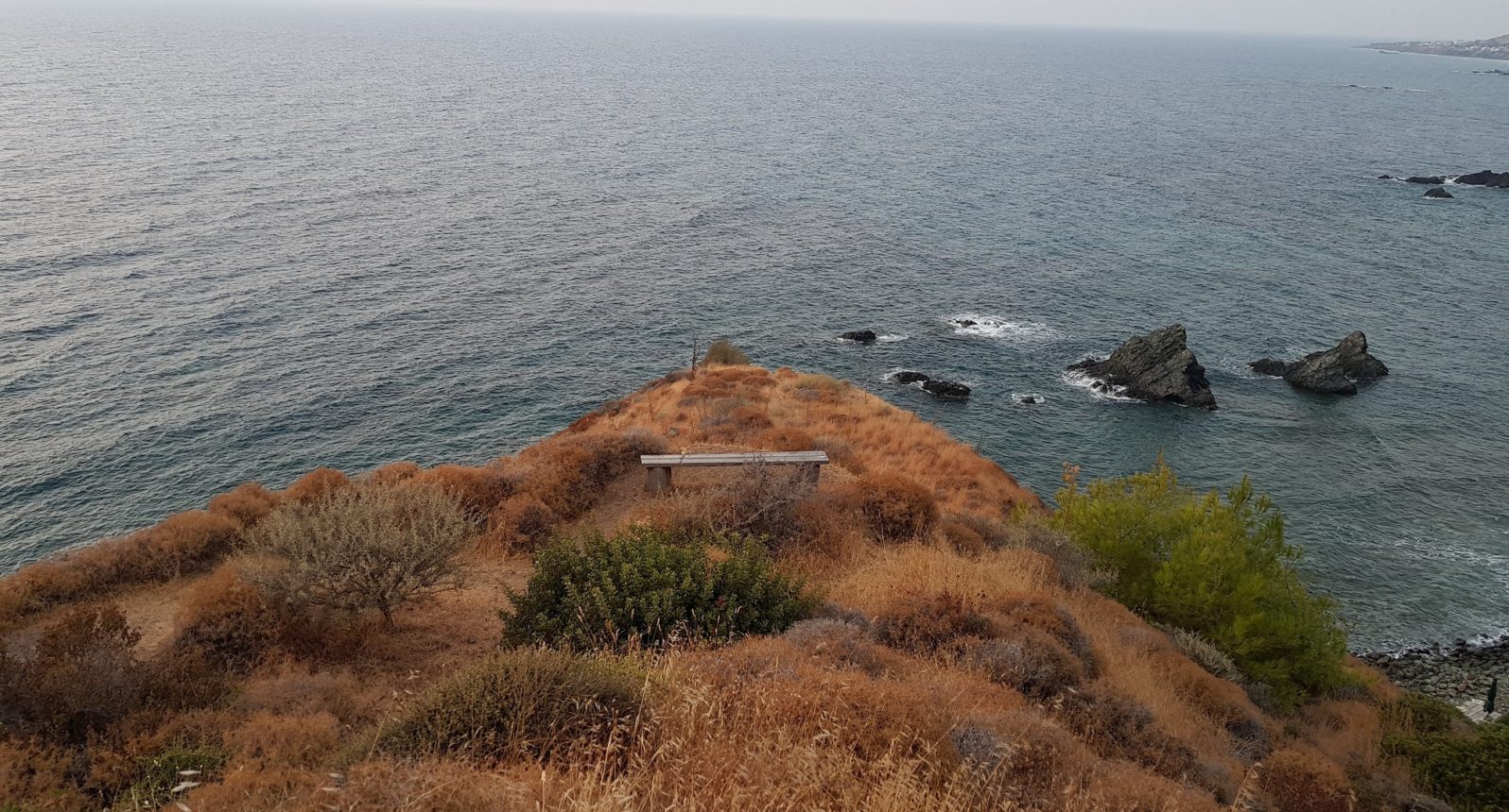 Felsvorsprung am Meer mit einer Bank