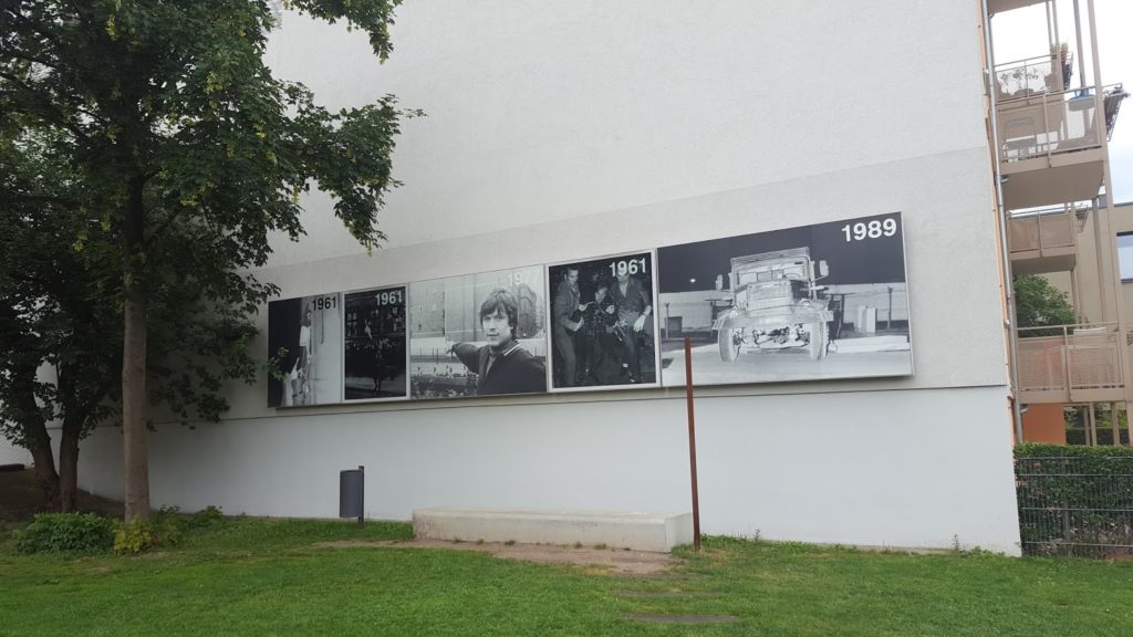 Fotos an einer Hauswand, die das Areal von 1961 bis 1989 zeigen.