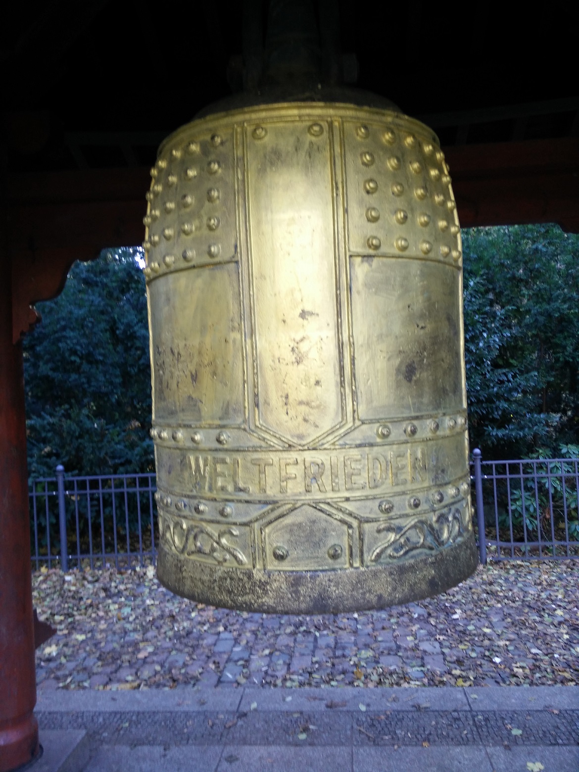 Blick auf die große goldfarbene Glocke mit der Inschrift "Weltfrieden".