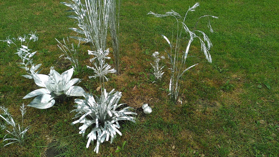 Gräser und Blumen aus Aluminium geformt.
