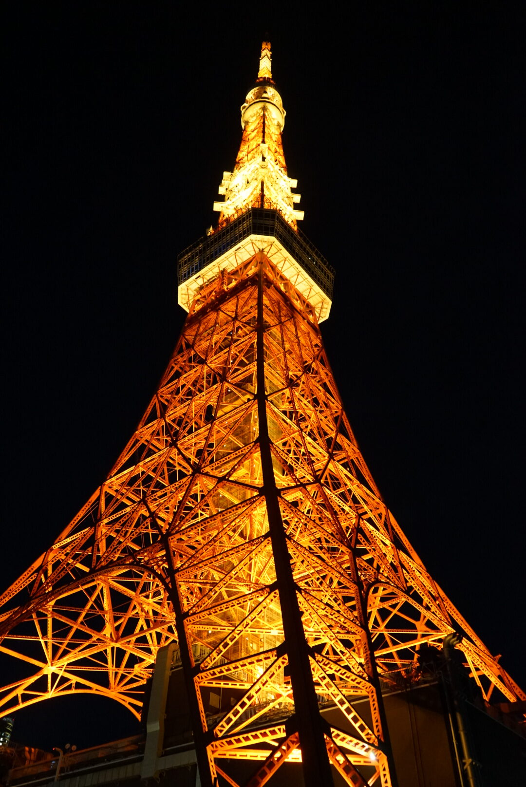 Der gelb-orange-leuchtende Tokyo Tower von unten.