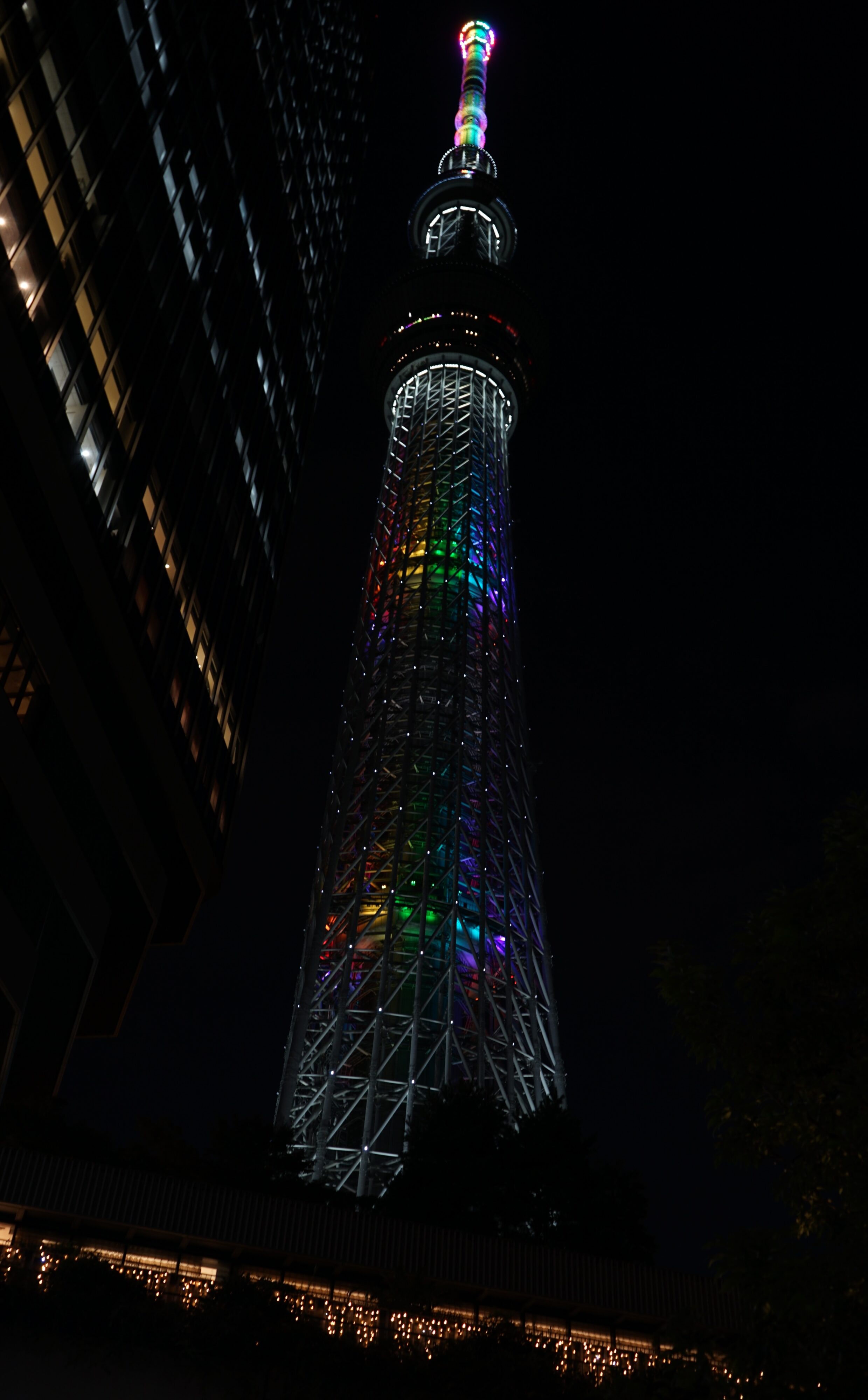 Tokyo Skytree bei Nacht in Regenbogenfarben leuchtend.