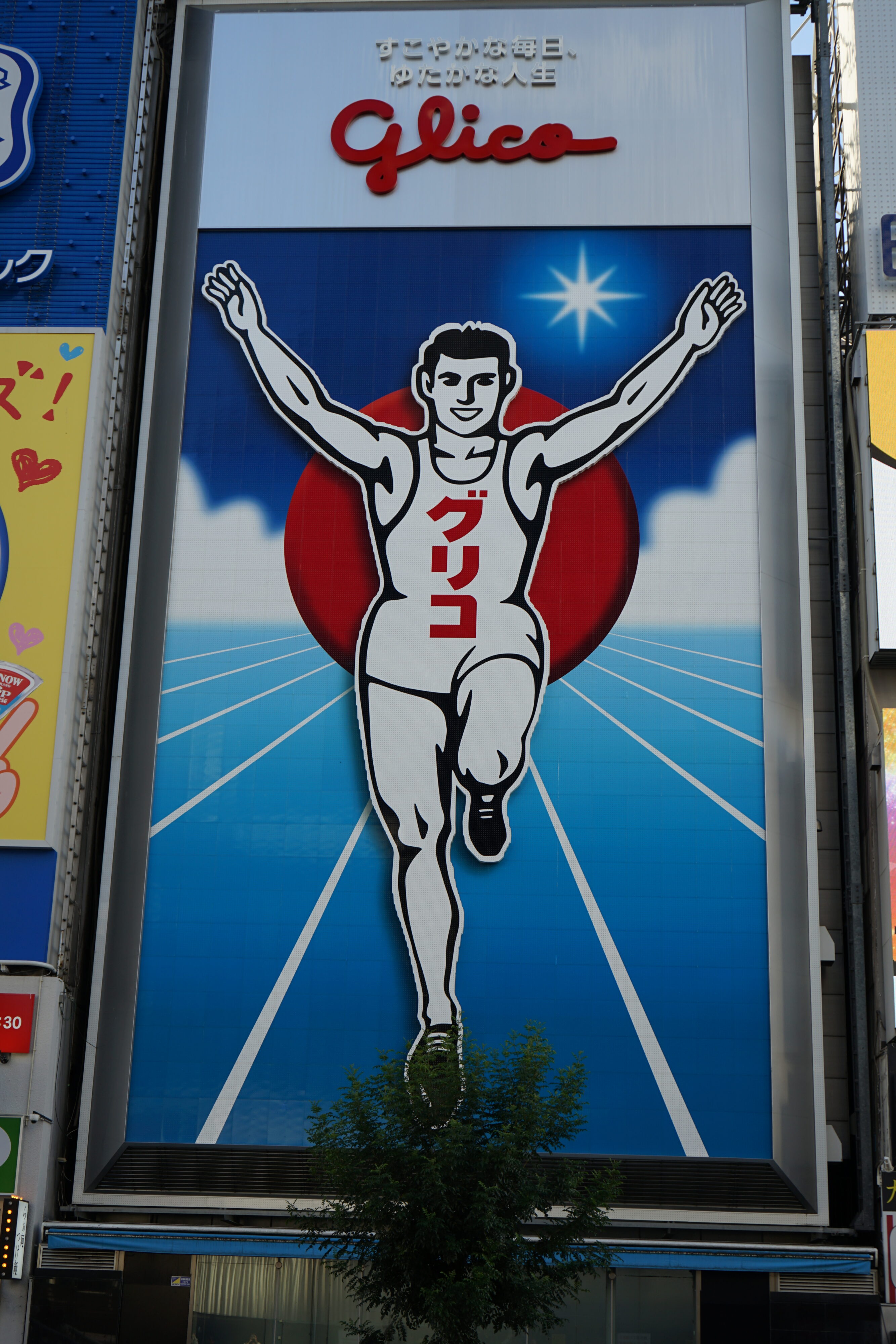 Ein Wahrzeichen von Osaka: der Running Man, eine weiße rennende Comicfigur, die die Arme hochreißt.