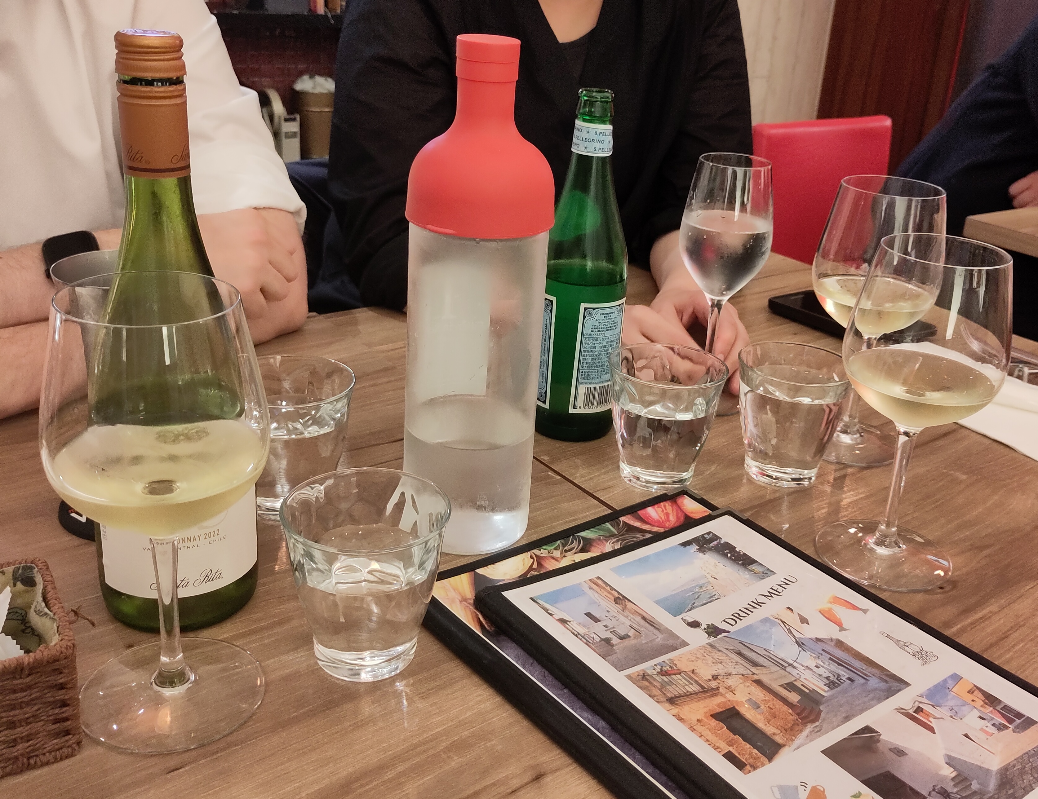 Tisch mit Weinflasche, Wasserflasche und Gläsern.