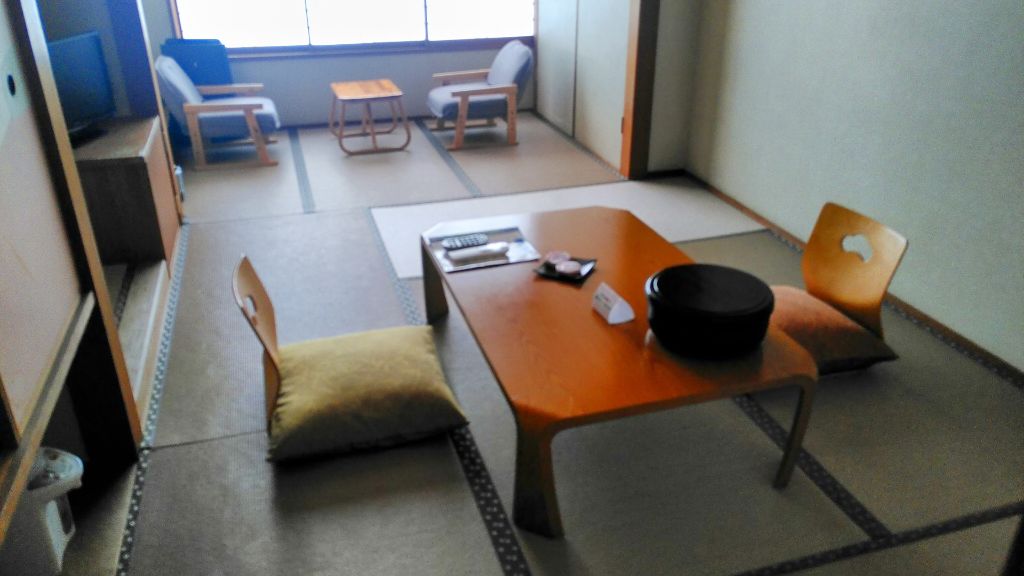 Blick auf ein Zimmer im japanischen Stil: Der Boden ist mit dünnen Matten ausgelegt. Die Stühle sind ohne Beine.