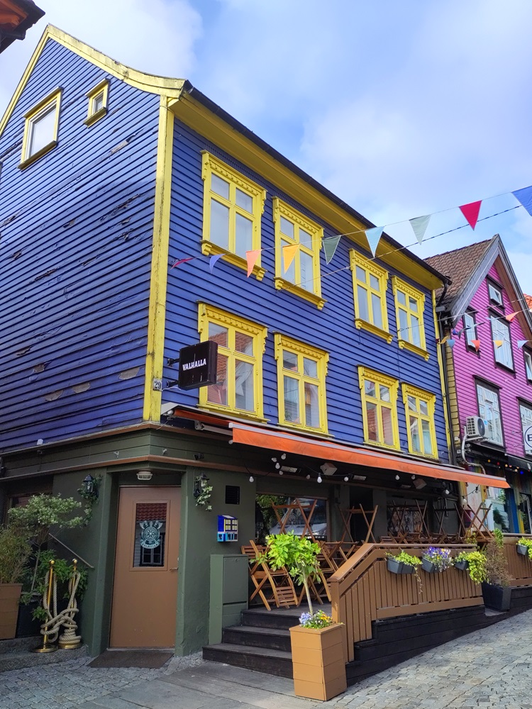 Ein blaues Haus mit gelb angemalten Fenstern.