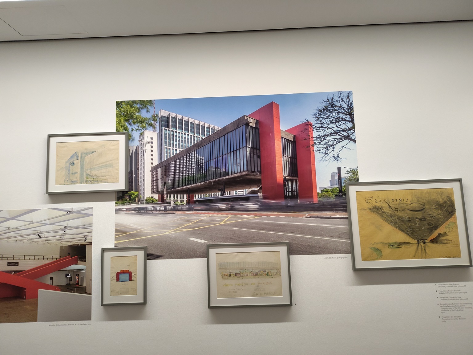 Blick auf eine Wand mit Fotos, Bildern und Architekturskizzen.