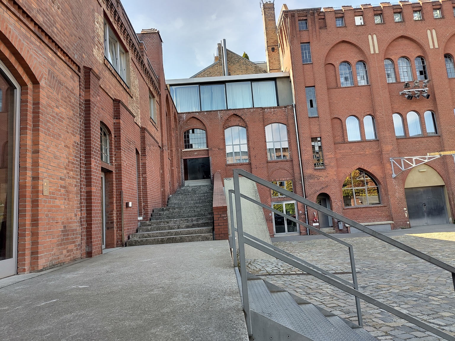 Blick auf rote Backsteinbauten und eine lang gezogene Treppe.