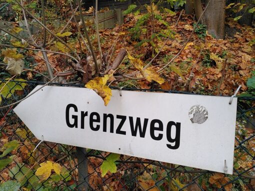 Weißes Schild auf dem "Grenzweg" steht.