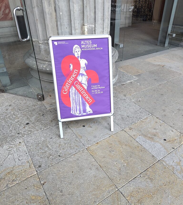 Eingangsbereich am Alten Museum mit einem Aufsteller zur Sonderausstellung "Göttinnen und Gattinnen".