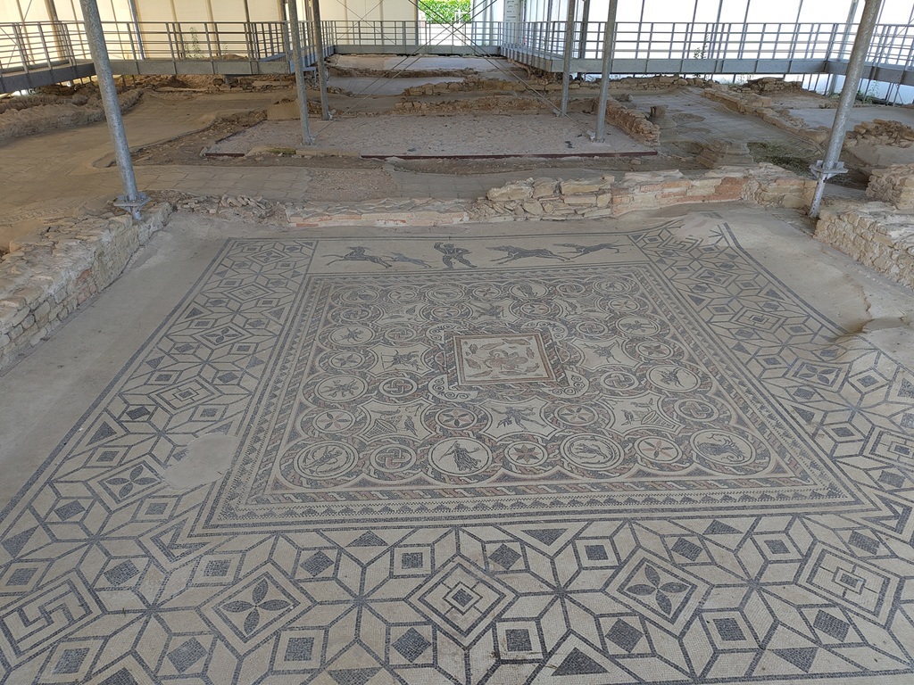 Mosaik im Domus del Mito: zu sehen sind geometrische Formen und einzelne Jagd- und Tiermotive,