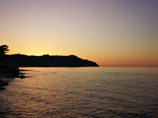 Blick auf das Meer und eine Landzunge in der Abenddämmerung.