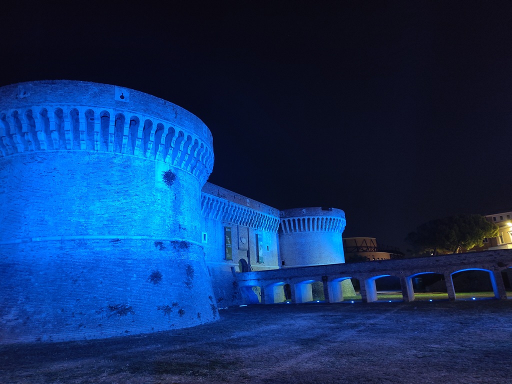 Blau angestrahlte Rocca Roveresca im Dunkeln.