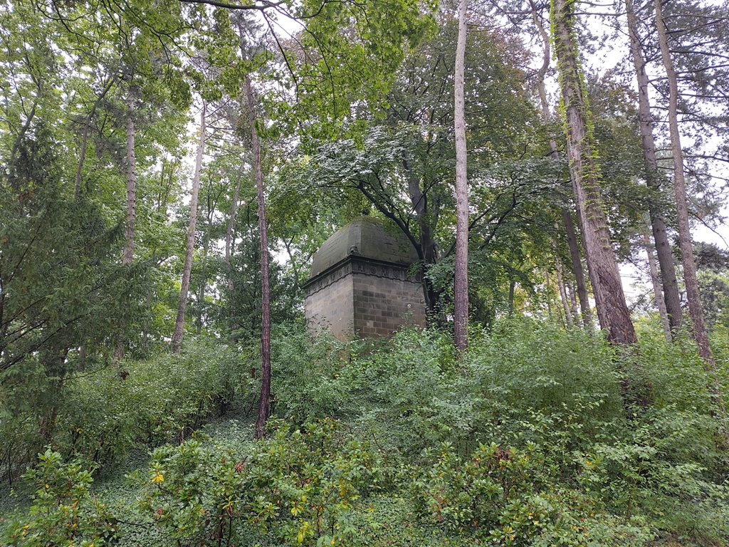 Runde Spitze des Kolumbariums umgeben von Sträuchern und Bäumen.