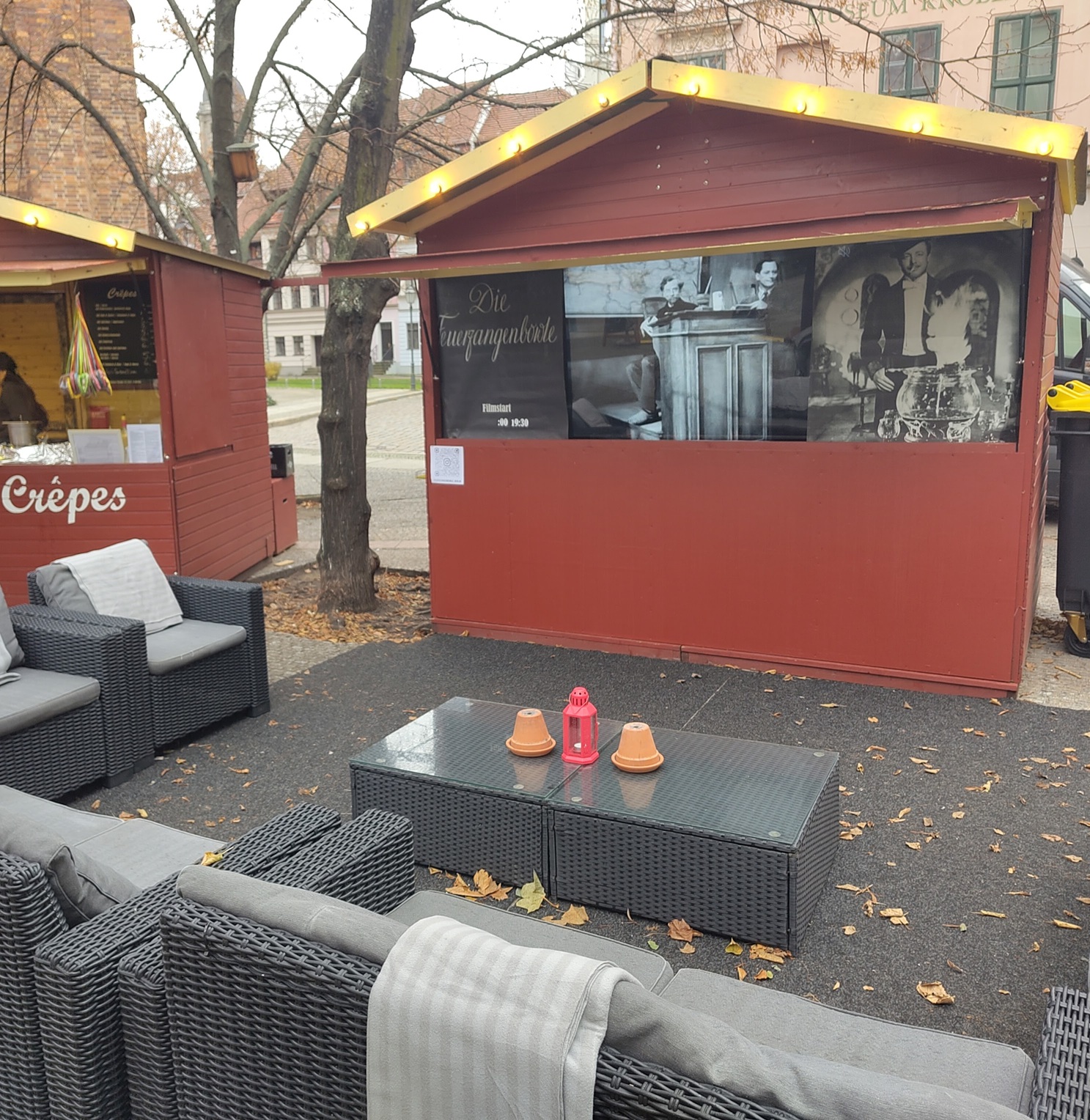 Blick auf Korbmöbel und einen Stand mit Leinwand für den Film Feuerzangenbowle.