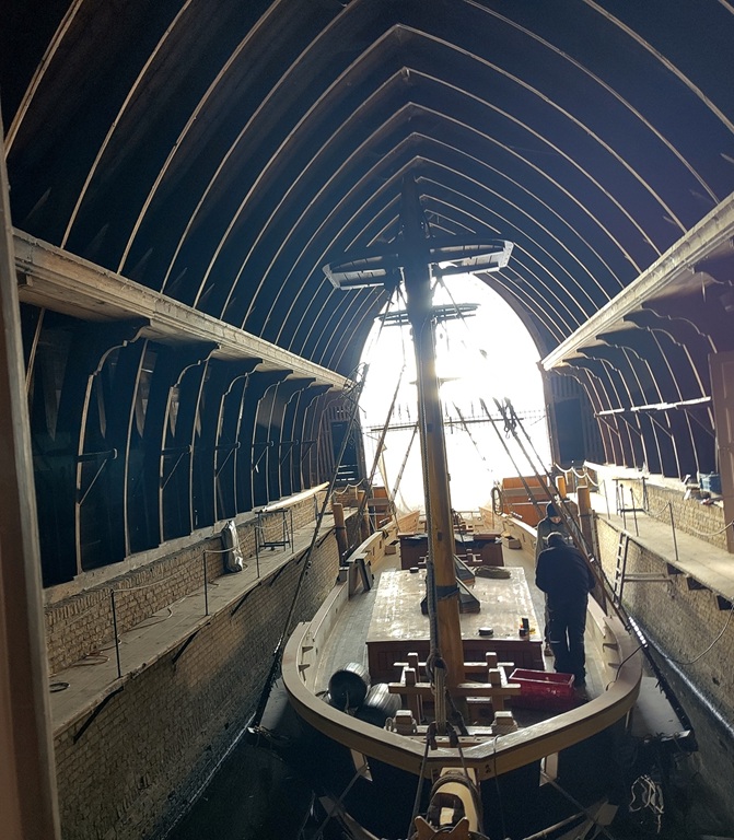 Blick ins Bootshaus mit dem Segelschiff.