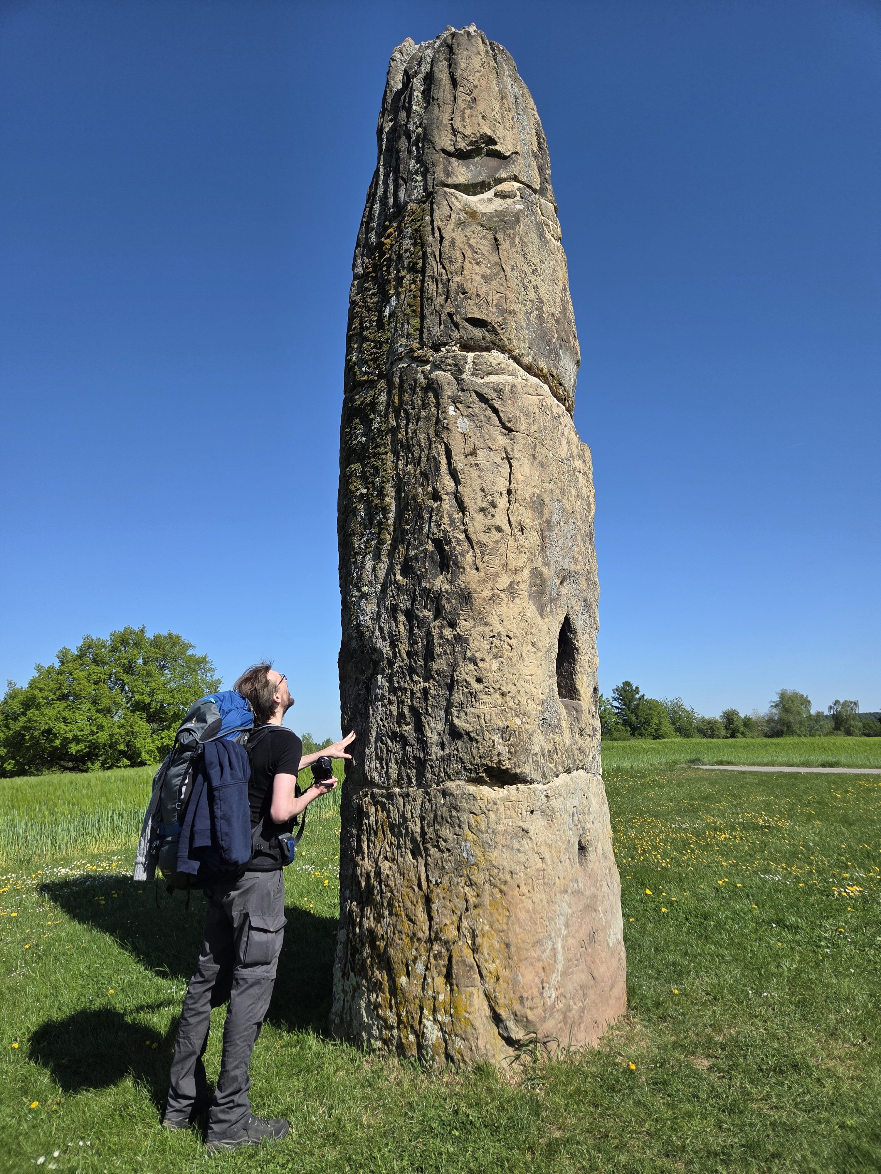 Gollenstein mit Inschriften. Neben dem Stein steht ein Mann.