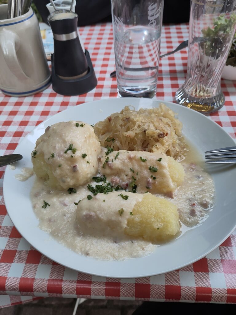 Längliche Klöße mit Sauerkraut und Sahnesoße.