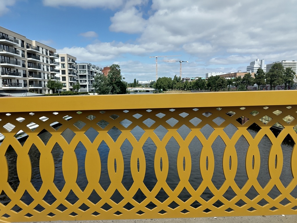 Die serschlungenen und zum Geländerrand hin eckigen Muster mit Freiräumen, durch die der Kanal zu sehen ist.